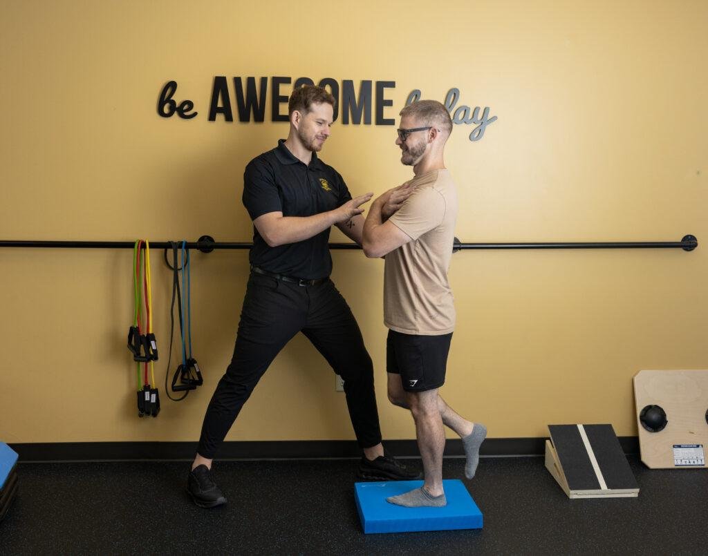 Physical therapist helping man with balance exercise