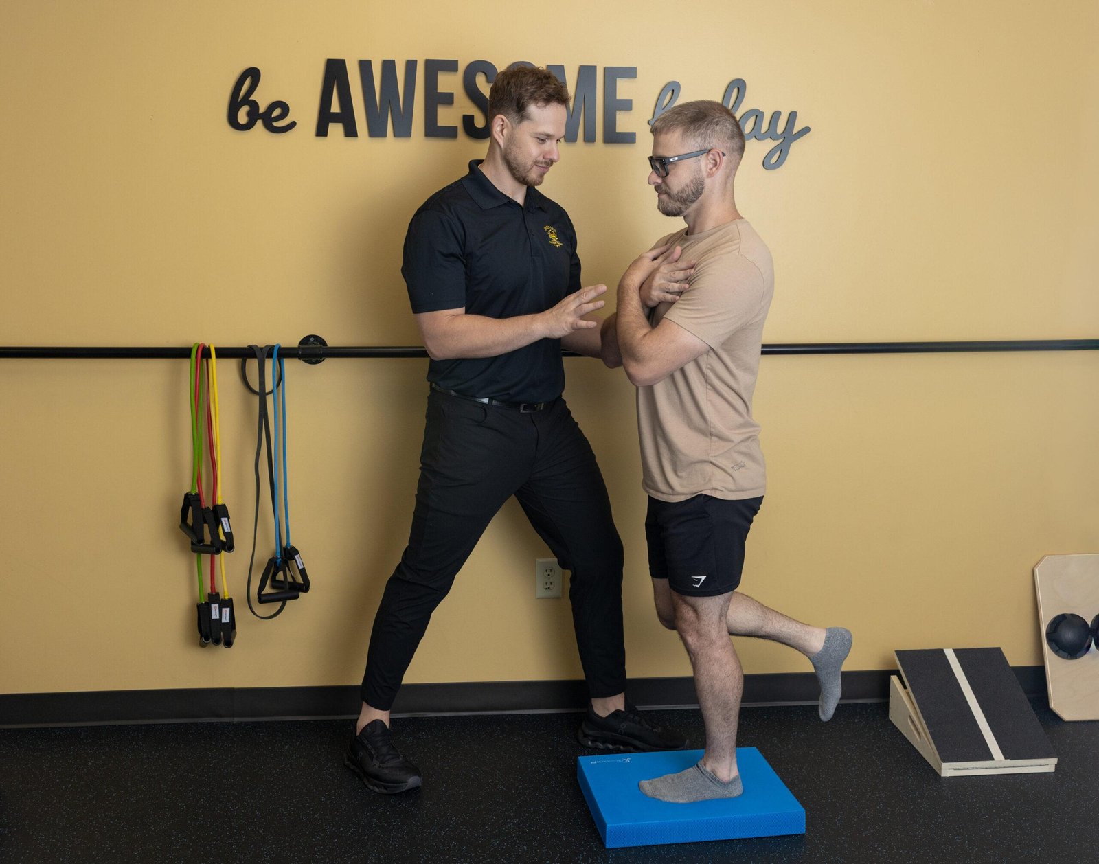 Physical therapist guiding man through balance exercise