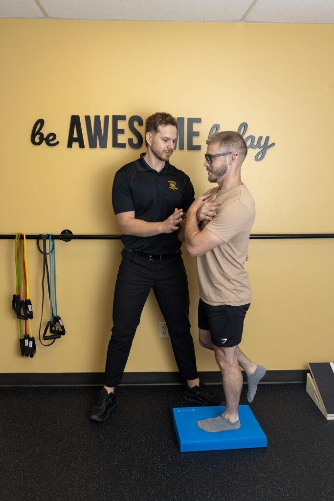 Physical therapist assisting balance exercise session