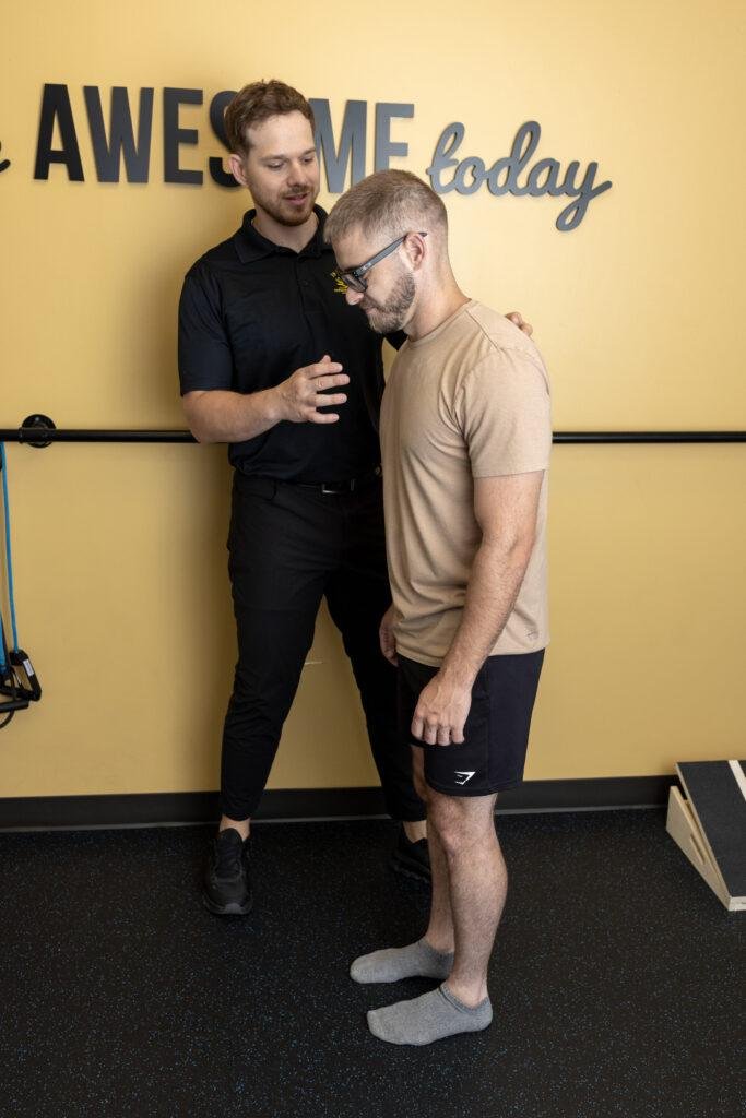 Trainer guiding man during physical therapy session