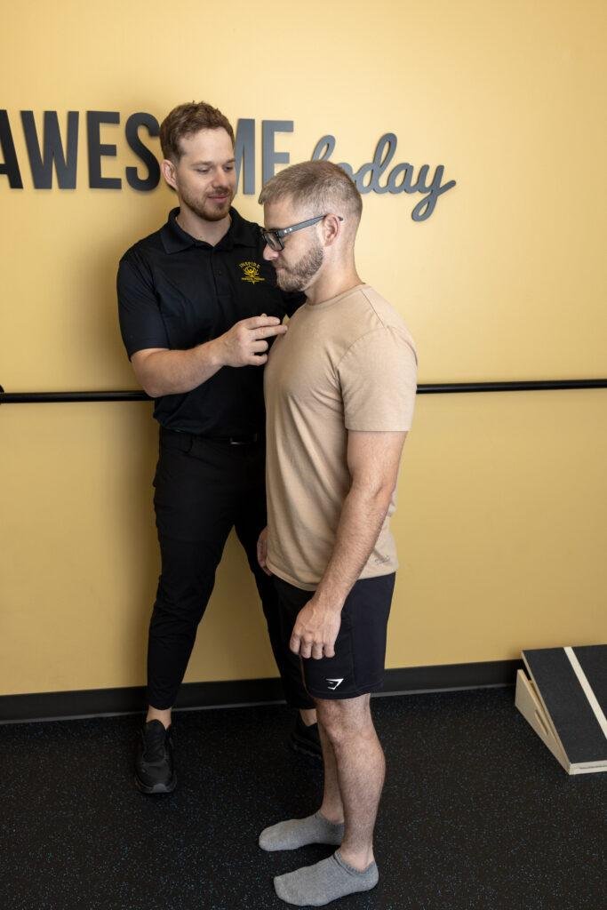 Therapist guiding man through posture exercise