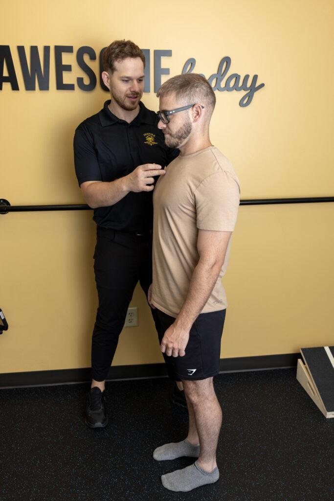 Trainer guiding man during posture exercise