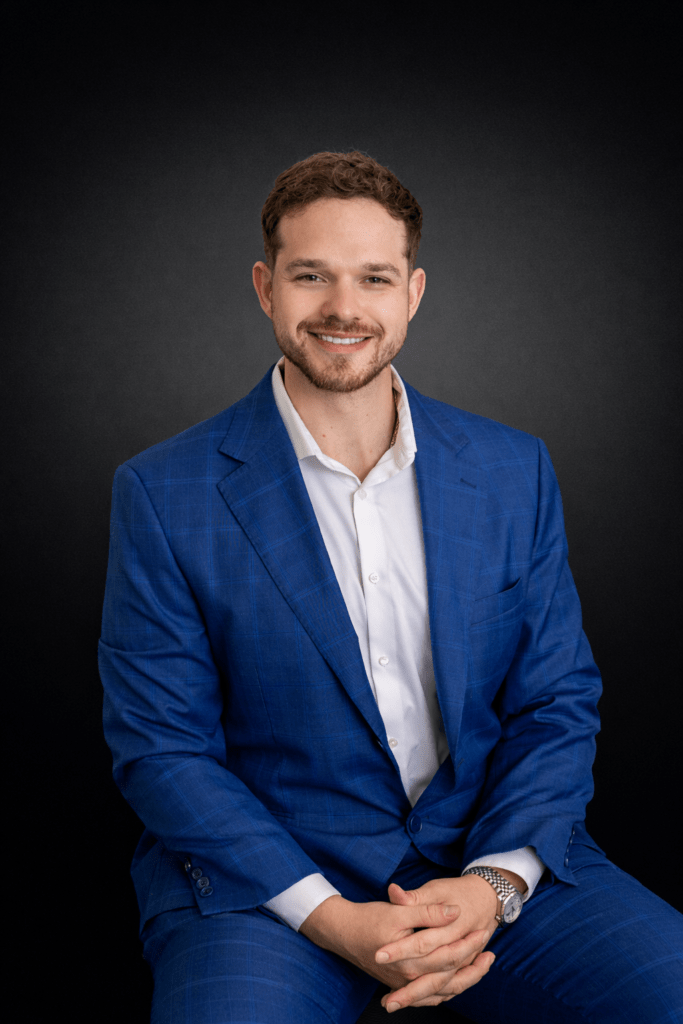 Smiling man in blue suit sitting confidently