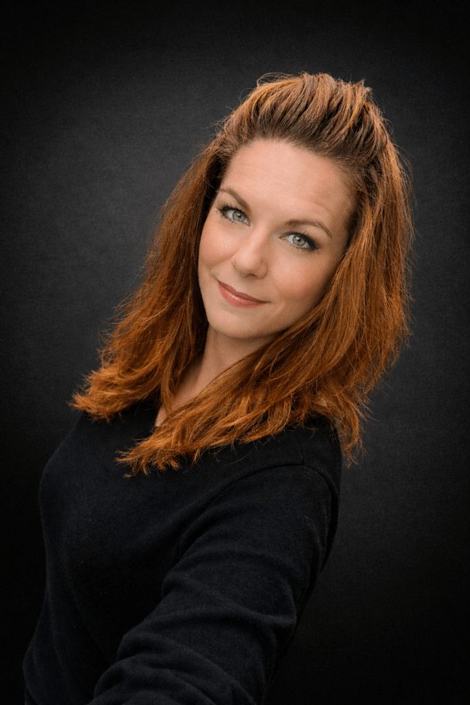 Smiling woman with red hair on dark background