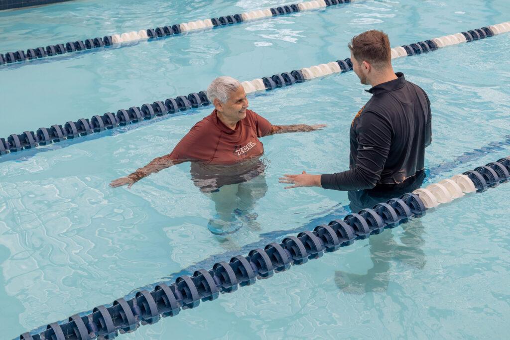 A physical therapist showing a patient aquatic therapy exercises in the Inspire Physical Therapy 365 Pool.